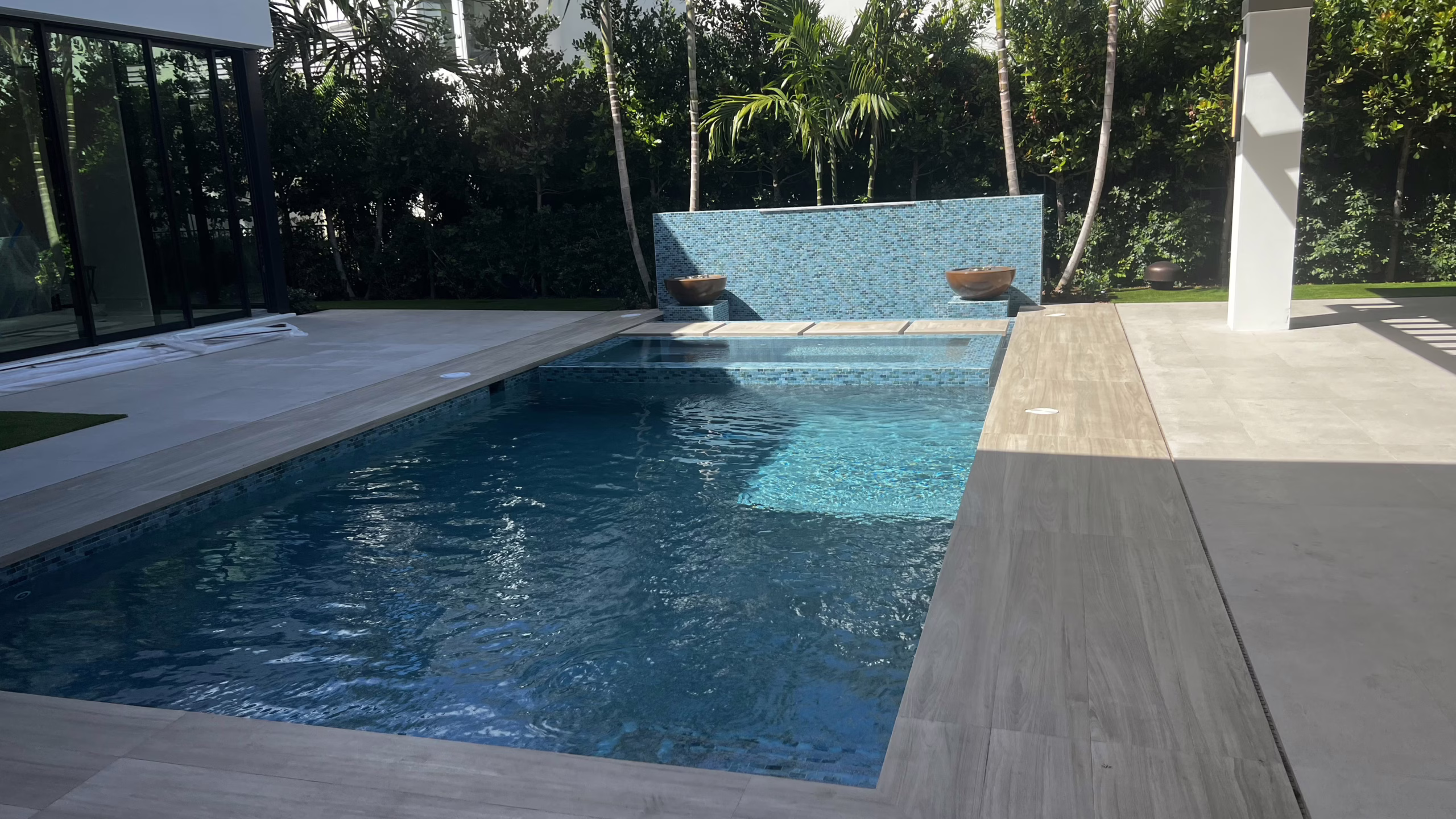 Luxury Jupiter outdoor audio installation featuring Triad Landscape speakers integrated with stone waterfall lighting.